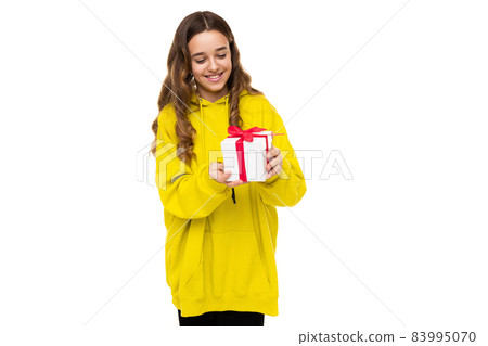 Photo of a beautiful adorable positive happy smiling brunette teenage girl in a stylish yellow 83995070