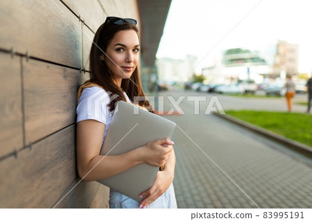 Photo of pretty attractive beautiful smiling positive charming young brunette young woman holding Photo of pretty attractive beautiful smiling positive charming young brunette young woman holding 83995191