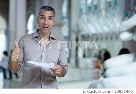 Adult man is visiting museum and looking at the exposition Adult man is visiting museum and looking at the exposition 83995490