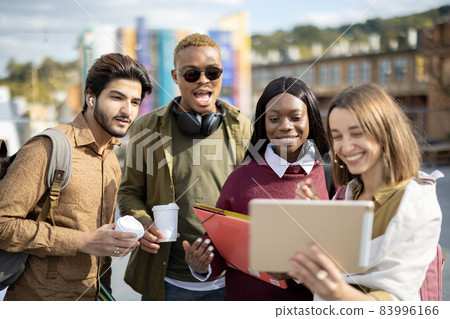 Students watch some on digital tablet outdoors Students watch some on digital tablet outdoors 83996166
