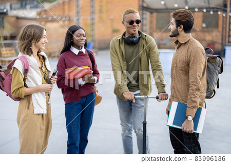Students walk together at university campus 83996186