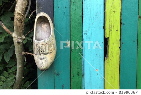 dutch wooden clog on colourful wall of painted wood dutch wooden clog on colourful wall of painted wood 83996367