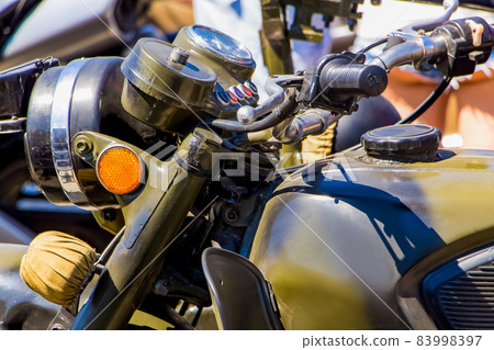 Motorcyclists celebrate Victory Day. Old military green motorcycle close-up. Motorcyclists celebrate Victory Day. Old military green motorcycle close-up. 83998397
