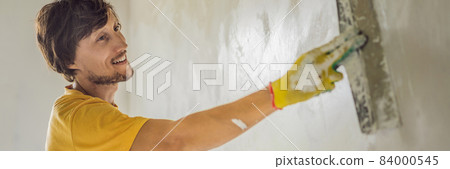 Plasterer home improvement handyman worker with putty knife working on apartment wall filling BANNER, LONG FORMAT 84000545