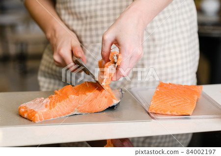 Removing fish bones. Butchering red fish meat. 84002197