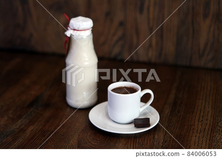 Traditional Mexican drink Horchata Latte - coffee mixed with Horchata, a cocktail of almonds in a bottle, rice vanilla. Cup of hot coffee with milk and chocolate on the surface placed on the wooden Traditional Mexican drink Horchata Latte - coffee mixed with Horchata, a cocktail of almonds in a bottle, rice vanilla. Cup of hot coffee with milk and chocolate on the surface placed on the wooden 84006053