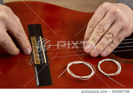 replacement and insertion of nylon strings in a classical guitar. lesson for a musician replacement and insertion of nylon strings in a classical guitar. lesson for a musician 84006790
