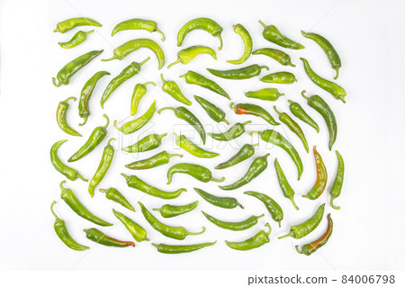 green hot peppers evenly spread on a white background. vitamin vegetables for health green hot peppers evenly spread on a white background. vitamin vegetables for health 84006798