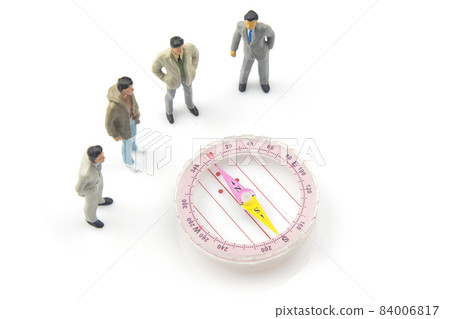 miniature people. different people are standing near the compass. finding direction in life 84006817