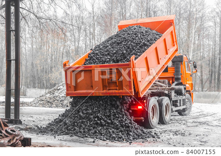 Dump truck in the industrial zone unloads coking coal from the body Dump truck in the industrial zone unloads coking coal from the body 84007155