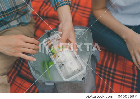 A couple having a picnic with a homemade bento A couple having a picnic with a homemade bento 84009697