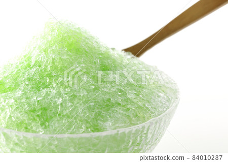 Shooting shaved ice with melon-flavored syrup on a white background Shooting shaved ice with melon-flavored syrup on a white background 84010287