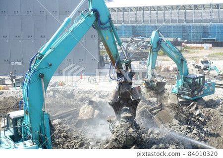 Building demolition work site with large heavy machinery demolished 84010320