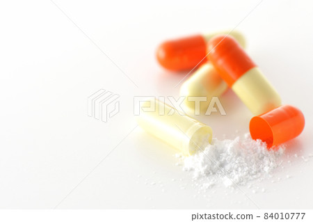 在白色背景上只取含有內容物的膠囊 在白色背景上只取含有內容物的膠囊 84010777