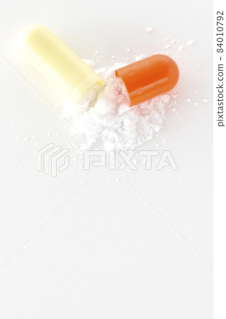 在白色背景上只取含有內容物的膠囊 在白色背景上只取含有內容物的膠囊 84010792