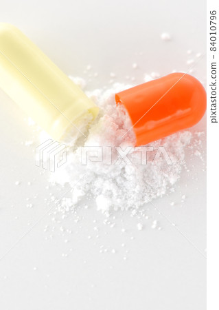 在白色背景上只取含有內容物的膠囊 在白色背景上只取含有內容物的膠囊 84010796