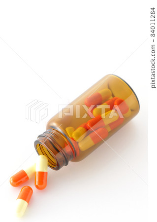 在白色背景上拍攝的小瓶和膠囊 84011284