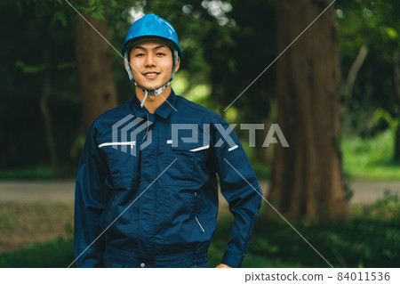 Park maintenance contractor wearing a helmet Park maintenance contractor wearing a helmet 84011536