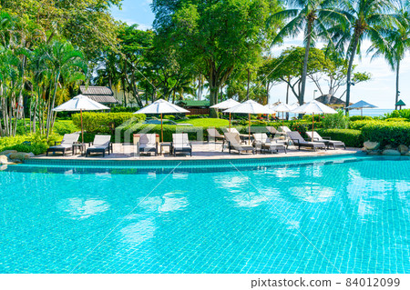 Beautiful umbrella and chair around swimming pool in hotel and resort Beautiful umbrella and chair around swimming pool in hotel and resort 84012099