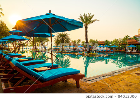 Beautiful umbrella and chair around swimming pool in hotel and resort 84012300