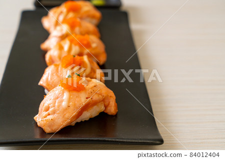 grilled salmon sushi on black plate 84012404