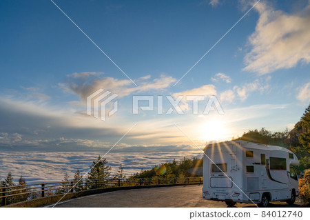A sea of clouds and a camper illuminated by the setting sun 84012740