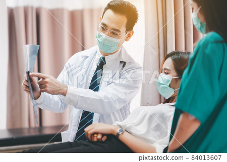 Doctor showing X-ray film results to woman patient,Infertility counseling and suggestion using new technology 84013607