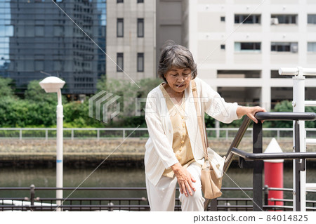 Knee pain senior female outdoor stairs Knee pain senior female outdoor stairs 84014825