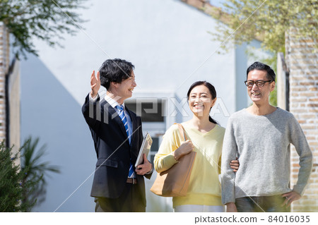 Middle-aged couple and businessman having business talks Middle-aged couple and businessman having business talks 84016035