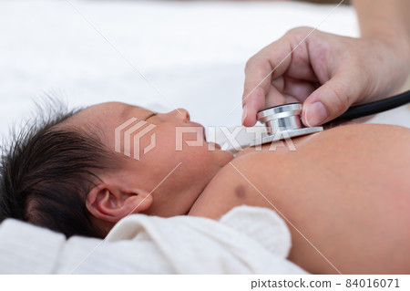 Unrecognizable Doctor heart check up and diagnosis baby newborn with stethoscope in clinic or hospital.Examining heartbeat of infant with stethoscope on chest sick baby.Baby Health Care Concept 84016071