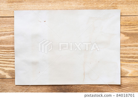 Sheet of paper lying on wooden table Sheet of paper lying on wooden table 84018701