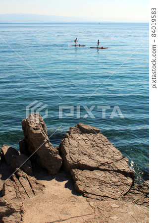 View from Icici's seaside promenade, the rocky beach with surfers,Adriatic coast, Kvarner bay, city details, Croatia View from Icici's seaside promenade, the rocky beach with surfers,Adriatic coast, Kvarner bay, city details, Croatia 84019583
