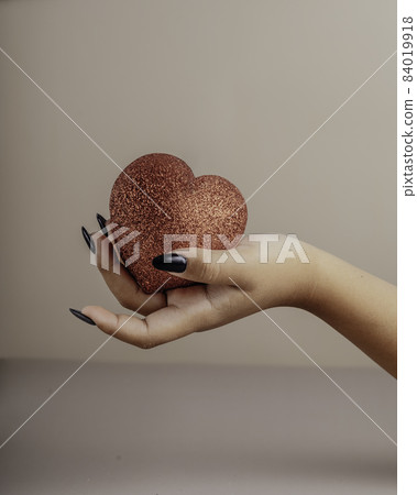Halloween theme: hand with black nails hold torn bleeding human heart Halloween theme: hand with black nails hold torn bleeding human heart 84019918