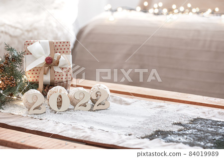 Christmas composition with numbers 2022 on blurred background with bokeh. Christmas composition with numbers 2022 on blurred background with bokeh. 84019989