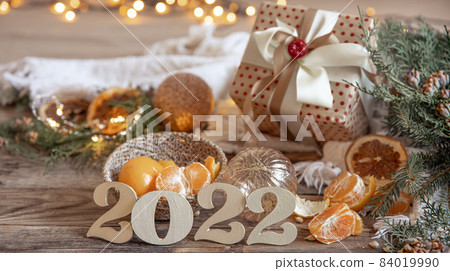 Christmas composition with decorative numbers 2022, mandarins and decor details. Christmas composition with decorative numbers 2022, mandarins and decor details. 84019990