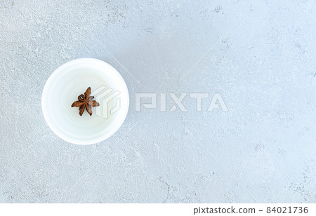 Anise on a white plate, on a gray background Anise on a white plate, on a gray background 84021736