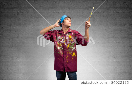 Young painter artist pointing upwards Young painter artist pointing upwards 84022155