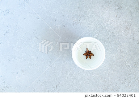 Anise on a white plate, on a gray background Anise on a white plate, on a gray background 84022401