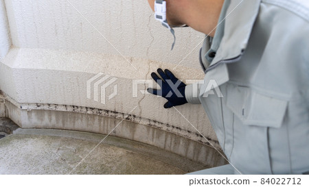 Workers inspecting deterioration and cracks on the outer wall Workers inspecting deterioration and cracks on the outer wall 84022712