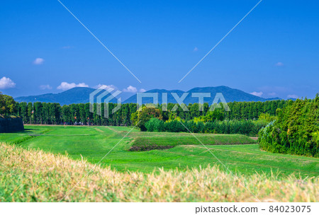 View of grass green field, trees and Tuscany hills 84023075