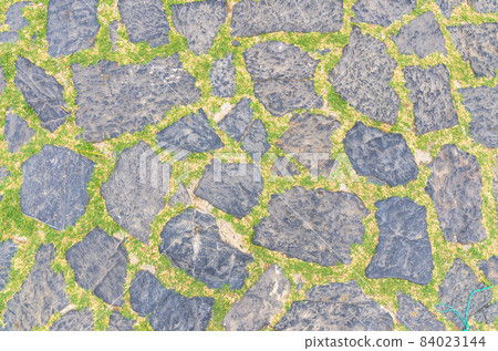 Cobblestone pavement background with copy space. Abstract old close-up cobble stone texture 84023144