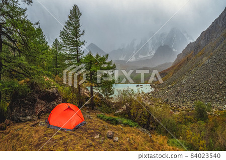 Bad weather on a hike, camping in the rain. Morning rain and fog near a mountain lake, Shavlin lake Altai, a tent camp in the fog. Bad weather on a hike, camping in the rain. Morning rain and fog near a mountain lake, Shavlin lake Altai, a tent camp in the fog. 84023540