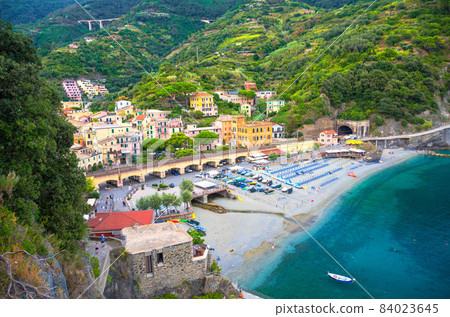 Top aerial view of green hill, railway, beach and harbor of Monterosso town 84023645