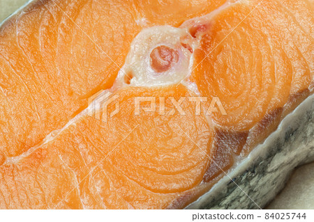 Proper healthy nutrition. Raw red salmon fish slice close-up with texture. Product containing vitamin D, A, B, C, PP phosphorus, iodine, calcium, potassium, sodium, magnesium, zinc, fluorine, omega-3 84025744