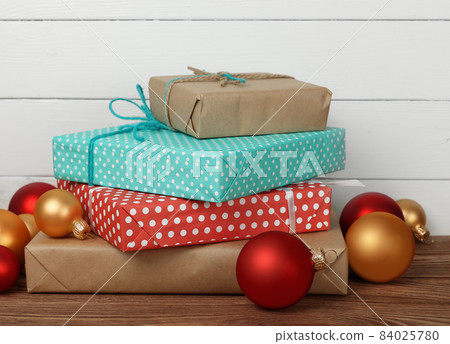 Stack of wrapped gifts on table 84025780