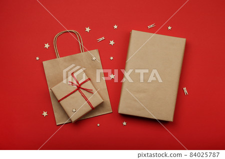 Packing Christmas gifts with red and brown paper 84025787