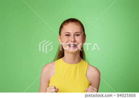 happy surprised redhead teen girl on green background. happy surprised redhead teen girl on green background. 84025808