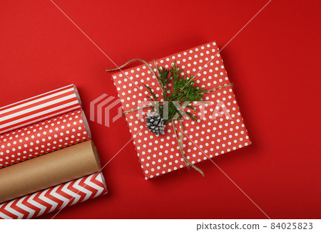 Packing Christmas gifts with red and brown paper 84025823