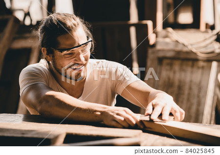 Young Carpenter happy working to making woodcraft furniture in wood workshop look professional high skill real people workman. 84025845