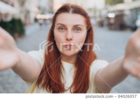 Lovely woman making selfie while walking past old building. Carefree and happy, sunny summer mood. Online communication concept Lovely woman making selfie while walking past old building. Carefree and happy, sunny summer mood. Online communication concept 84026057